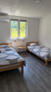 a room with two beds and a table and two windows at Villa EMELA in Jajce