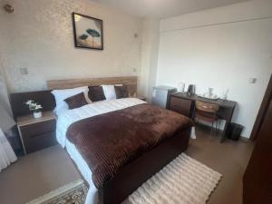 a bedroom with a bed and a desk and a sink at Maison Babacar TOURE in Dakar