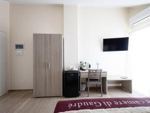 a room with a desk and a table and a cabinet at Le camere di Gaudré in Battipaglia