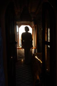 a person standing in a hallway looking out a window at Berber Beldi Camp in Imsouane