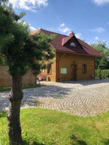ein Haus mit einem Baum davor in der Unterkunft Wichrowe Wzgórze in Dynów