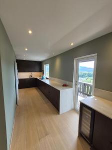 a large kitchen with a counter and a large window at Villa Strand in Skodje