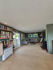 a living room with a library with bookshelves at Villa Strand in Skodje