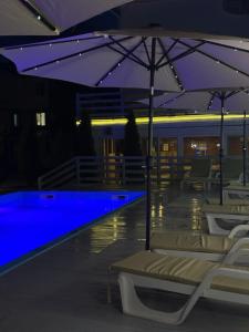 a swimming pool with umbrellas and chairs in a building at Aquamarin in Zatoka +27 photos