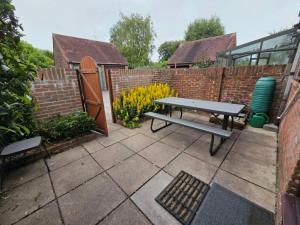 a patio with a picnic table and a fence at 3 bed house in Winterbourne Abbas in Winterborne Abbas
