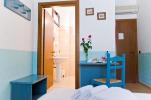 a bedroom with a blue desk and a blue chair at History Hotel in Valderice