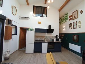 a kitchen with a white refrigerator and a stove at La Pépite du Sauternais in Preignac