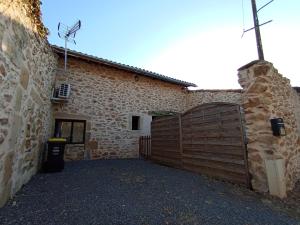 a building with a wooden gate in front of it at La Pépite du Sauternais in Preignac