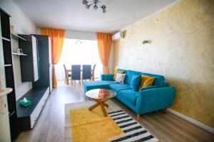 ein Wohnzimmer mit einem blauen Sofa und einem Tisch in der Unterkunft Sun View Boulevard in Alba Iulia