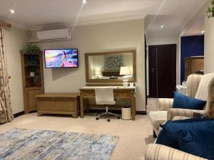 a living room with a desk and a tv on the wall at Marble on 8 in Rustenburg