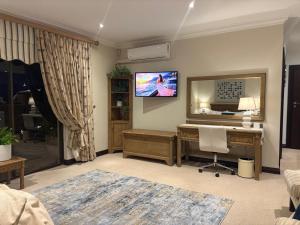 a living room with a desk and a mirror at Marble on 8 in Rustenburg