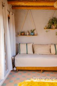 a bed in a room with plants on the wall at Berber Beldi Camp in Imsouane