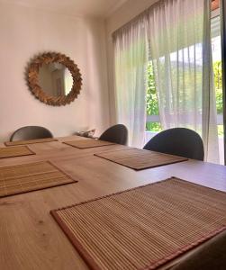 a large wooden table with chairs and a mirror at O Jardim Mágico in Teixoso