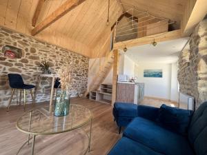 a living room with a blue couch and a glass table at Ty glaz in Plouguerneau +12 photos