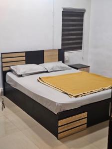 a bed with a yellow blanket on top of it at Relaxinn Dwaraka in Mānantoddy +2 photos