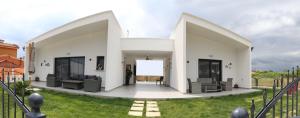 a white house with chairs and a yard at VenisHome 2 in Chrysoupolis