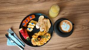 a plate of breakfast food and a glass of orange juice at Hotel Molinos by Growing Group in Medellín