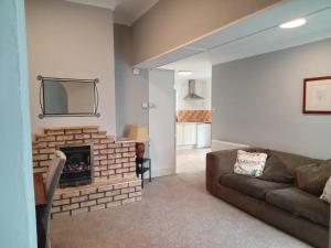 a living room with a couch and a brick fireplace at Comfy Home in Castlebar