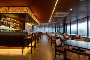 un ristorante con tavoli, sedie e un bar di Hotel Mandu a Teresina