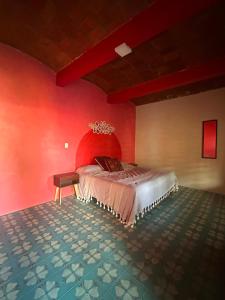 a bedroom with a bed in a red wall at Ojo de Luna Teotitlan in Teotitlán del Valle