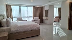 ein Schlafzimmer mit einem großen Bett und zwei Stühlen in der Unterkunft فندق جواهر العبدلي - Jawaher Hotel in Amman + 70 Fotos