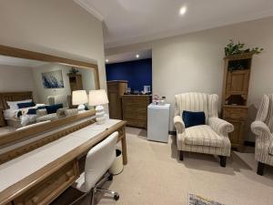 a bedroom with a bed and chairs in a room at Marble on 8 in Rustenburg