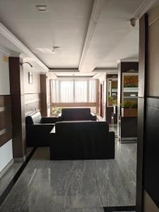 a living room with black couches in a room at Continento the classic hotel in Malappuram