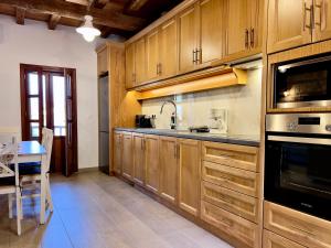 a large kitchen with wooden cabinets and a table at Twin vista getaway in Meyisti