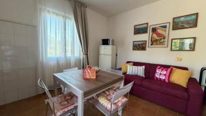 a living room with a purple couch and a table at Casa Irene in Marina di Massa