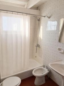 a bathroom with a toilet and a tub and a sink at Olly Patagonia Suites in San Carlos de Bariloche