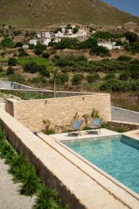 a swimming pool with two chairs sitting next to it at Sage Suite in Paránimfoi +17 photos