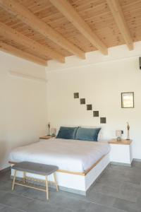 a bedroom with a white bed and wooden ceilings at Sage Suite in Paránimfoi