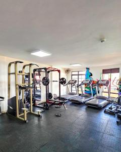 a gym with a bunch of treadms and machines at The Royals in Tatu City