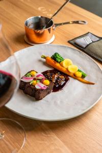 a plate of food with carrots and meat on a table at ARTEVINI Resort & Winery in Velké Pavlovice