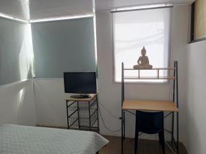 a room with a bed and a desk and a window at Puruha Inn in Riobamba