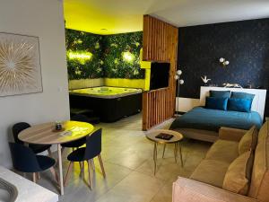 a bedroom with a bed and a tub in a room at Spa des Sacres - Suite avec Jacuzzi Privatif in Reims