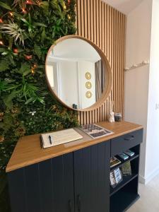 a mirror on top of a dresser in a room at Spa des Sacres - Suite avec Jacuzzi Privatif in Reims +32 photos