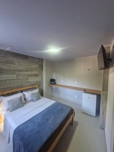 a bedroom with a large bed and a television at Loft da Árvore in Petrópolis