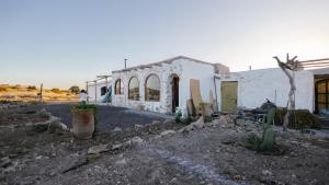 a white building with some plants in front of it at Berber Beldi Camp in Imsouane