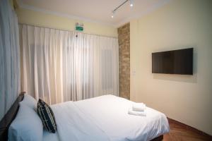 a bedroom with a bed and a flat screen tv at DoDo Apartments in Hanoi