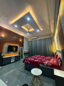 a bedroom with a red bed and a flat screen tv at Craviq Hotels -1 in Ghaziabad