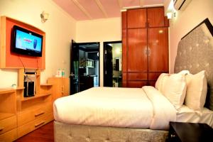 a bedroom with a bed and a flat screen tv at Craviq Hotels -1 in Ghaziabad