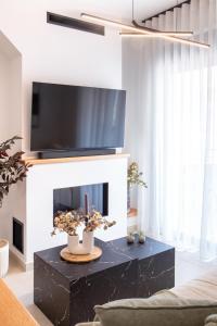ein Wohnzimmer mit Kamin und darüber ein Fernseher in der Unterkunft Mad Spaces in Volos