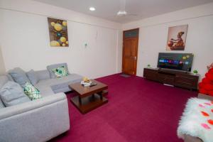 a living room with a couch and a tv at Zanzibar Rahaa in Dar es Salaam