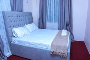 a bed in a room with a large window at Zanzibar Rahaa in Dar es Salaam