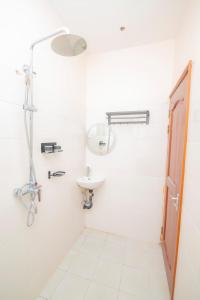 a white bathroom with a sink and a shower at Zanzibar Rahaa in Dar es Salaam