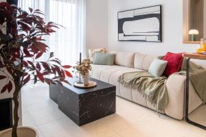 ein Wohnzimmer mit Sofa und Topfpflanze in der Unterkunft Mad Spaces in Volos