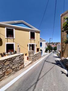a house with a stone wall on the side of a street at Twin vista getaway in Meyisti