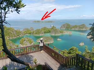 a person standing on a bridge looking out over a lake at Lagoon Homestay in Keruo