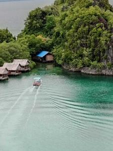 a small boat in the water next to a island at Lagoon Homestay in Keruo